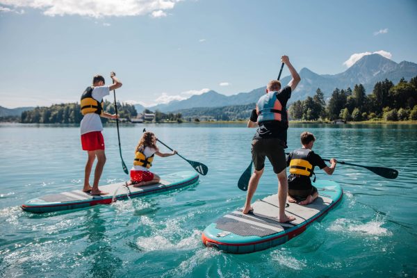 Lehrlinge paddeln auf Surfbrettern im See